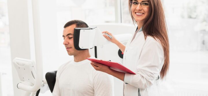 smiling-doctor-holding-clipboard-checking-patient_23-2148328403